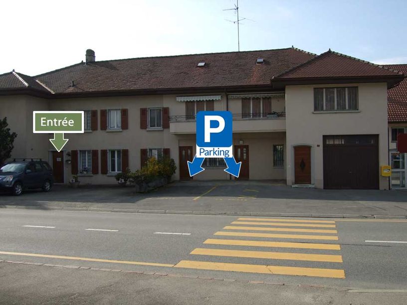 Photo du cabinet depuis l'extérieur avec l'indication de l'entrée et des places de parking